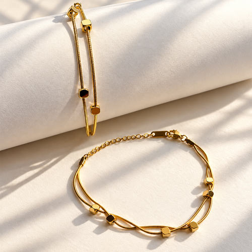 Gold-tone double layer bracelet with polished geometric details styled on soft ivory fabric.